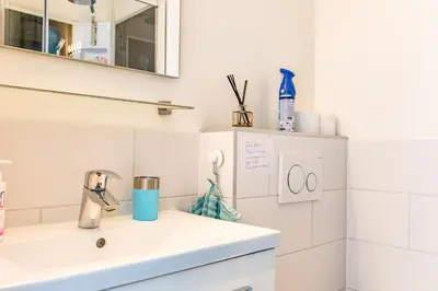 a white bathroom with a sink and a mirror at The New Lake Boathouse in Amsterdam