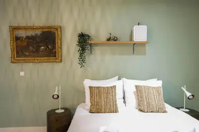 a bed with white sheets and pillows in a bedroom at NEW! Modern Gallery Nassau Canal Suite in Amsterdam