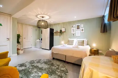 a bedroom with two beds and a living room at NEW! Modern Gallery Nassau Canal Suite in Amsterdam