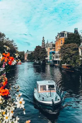 a boat floating down a river in a city at NEW! Modern Gallery Nassau Canal Suite in Amsterdam