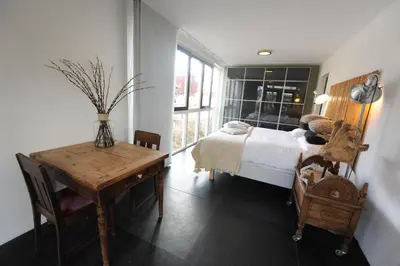 a bedroom with a bed and a desk and a table at The Green Tunnel in Amsterdam