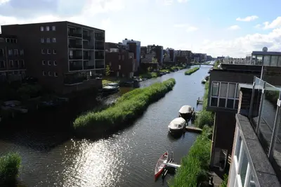 a river with boats in it and some buildings at The Green Tunnel in Amsterdam