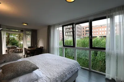 a bedroom with a bed and a large window at The Green Tunnel in Amsterdam