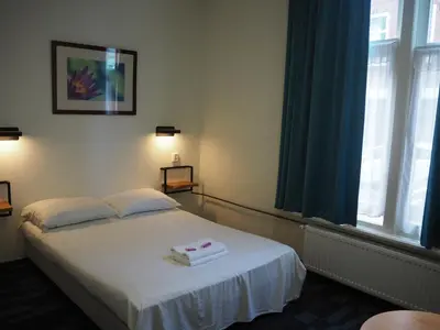 a hotel room with a bed with a box on it at Euphemia Budget Old City Canal Zone in Amsterdam