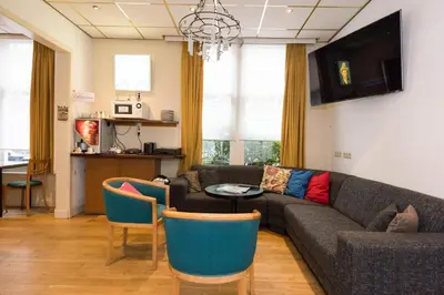 a living room with a couch and a table and chairs at Euphemia Budget Old City Canal Zone in Amsterdam