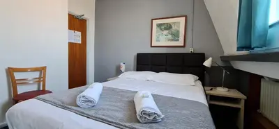 a bedroom with a bed with towels on it at Euphemia Budget Old City Canal Zone in Amsterdam