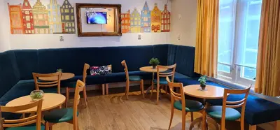 a restaurant with tables and chairs and a blue couch at Euphemia Budget Old City Canal Zone in Amsterdam