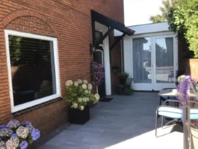 a patio with chairs and flowers next to a brick building at Sunny dunes in Zandvoort