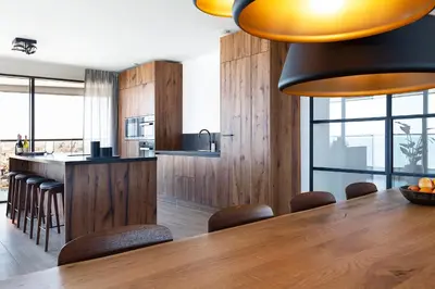 a kitchen with a large wooden table and chairs at Maris Apartments in Egmond aan Zee