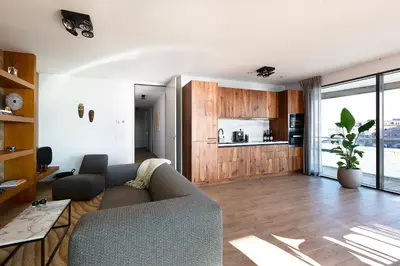 a living room with a couch and a kitchen at Maris Apartments in Egmond aan Zee