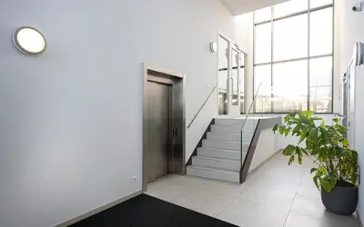 a hallway with a door and stairs in a building at Maris Apartments in Egmond aan Zee