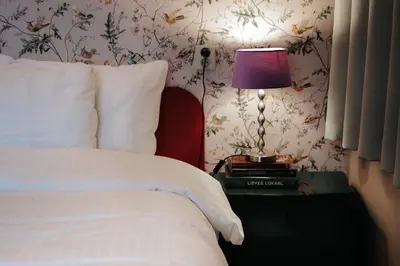 a bedroom with a bed and a lamp on a table at Rosalia's Menagerie Cocktail bar & InnUpstairs in Amsterdam