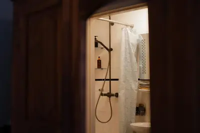 a bathroom with a shower curtain and a sink at Rosalia's Menagerie Cocktail bar & InnUpstairs in Amsterdam