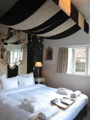 a bedroom with a large bed with towels on it at Rosalia's Menagerie Cocktail bar & InnUpstairs in Amsterdam