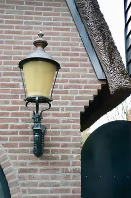 a street light on the side of a brick building at Cavalli's Cottage in Bilthoven
