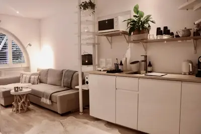 a living room with a couch and a kitchen at Cavalli's Cottage in Bilthoven