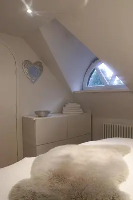 a bedroom with an attic with a heart on the wall at Cavalli's Cottage in Bilthoven