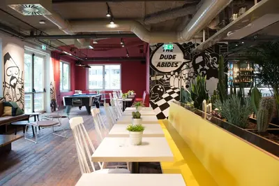 a dining room with tables and chairs and plants at Via Suites in Amsterdam