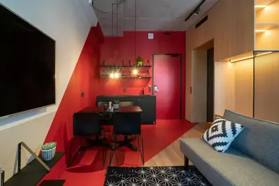 a living room with a red accent wall at Via Suites in Amsterdam