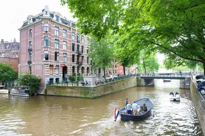 a group of people in a boat on a river at Hotel Amsterdam Inn in Amsterdam