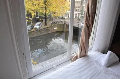 a room with a window with a view of a river at Hotel Amsterdam Inn in Amsterdam
