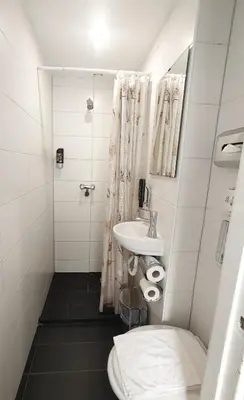 a small bathroom with a sink and a toilet at Hotel Amsterdam Inn in Amsterdam