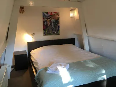a small bedroom with a bed in a room at Little Constantia in Bergen