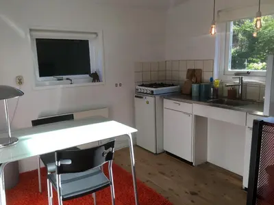 a kitchen with white appliances and a table and a window at Little Constantia in Bergen