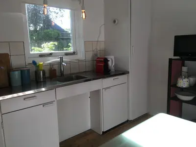 a white kitchen with a sink and a window at Little Constantia in Bergen