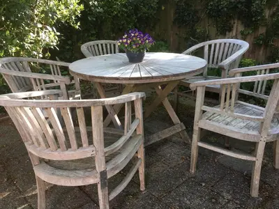 a wooden table and chairs with a potted plant on it at Little Constantia in Bergen