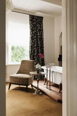 a bathroom with a chair and a bath tub at Inn on the Lake in Broek in Waterland