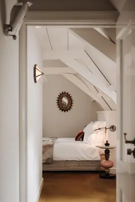 a bedroom with a bed in a white room at Inn on the Lake in Broek in Waterland