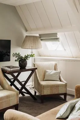 a living room with a table and chairs and a lamp at Inn on the Lake in Broek in Waterland