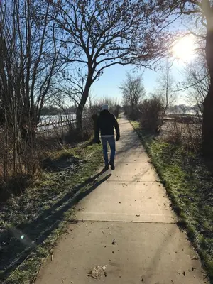 a man walking down a sidewalk on a path at Dobberhuisje in Nieuwkoop