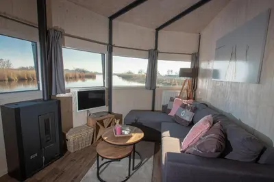 a living room with a couch and a tv at Dobberhuisje in Nieuwkoop