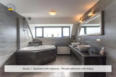 a bathroom with two sinks and a bath tub at Joy at the Beach in Zandvoort