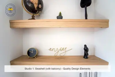 a wooden shelf on a wall with a clock at Joy at the Beach in Zandvoort