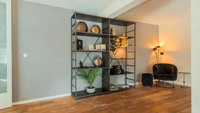 a black book shelf in a room with a chair at Villa De Stolp in Schoorl