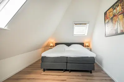 a bedroom with a bed in a attic at Villa De Stolp in Schoorl
