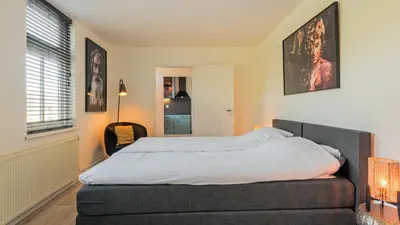 a bedroom with a bed and a window at Villa De Stolp in Schoorl