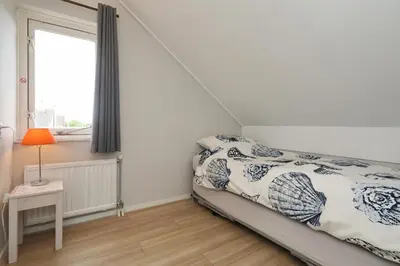a bedroom with a bed and a window at Paleisje Noordwijk in Noordwijk