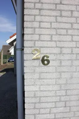 a white brick wall with a number on it at Paleisje Noordwijk in Noordwijk