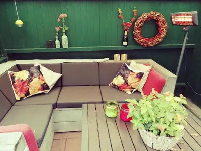 a couch with pillows and a table with plants at Gouweland in Hoogwoud