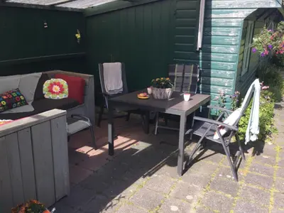 a patio with a table and chairs and a couch at Gouweland in Hoogwoud