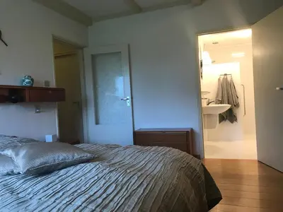 a bedroom with a bed and a bathroom with a mirror at Gouweland in Hoogwoud