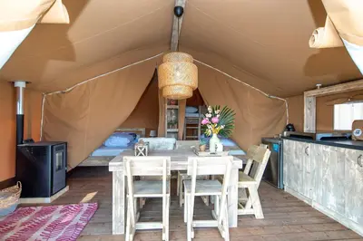 a dining room in a tent with a table and chairs at Marinaparcs Almere in Almere
