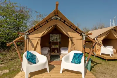 a tent with two chairs and beds in it at Marinaparcs Almere in Almere