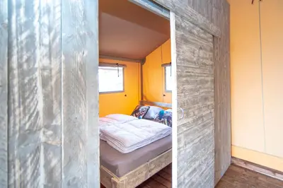 a small bedroom with a bed in a wooden wall at Marinaparcs Almere in Almere