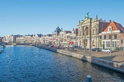 a river in a city with houses and buildings at Studio Haarlemenmeer in Cruquius