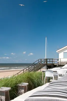 a beach with tables and chairs and the ocean at Studio Haarlemenmeer in Cruquius